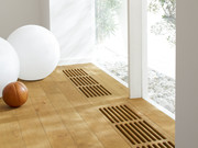 Real wood parquet floor with ventilation grids in front of glazed rear wall.